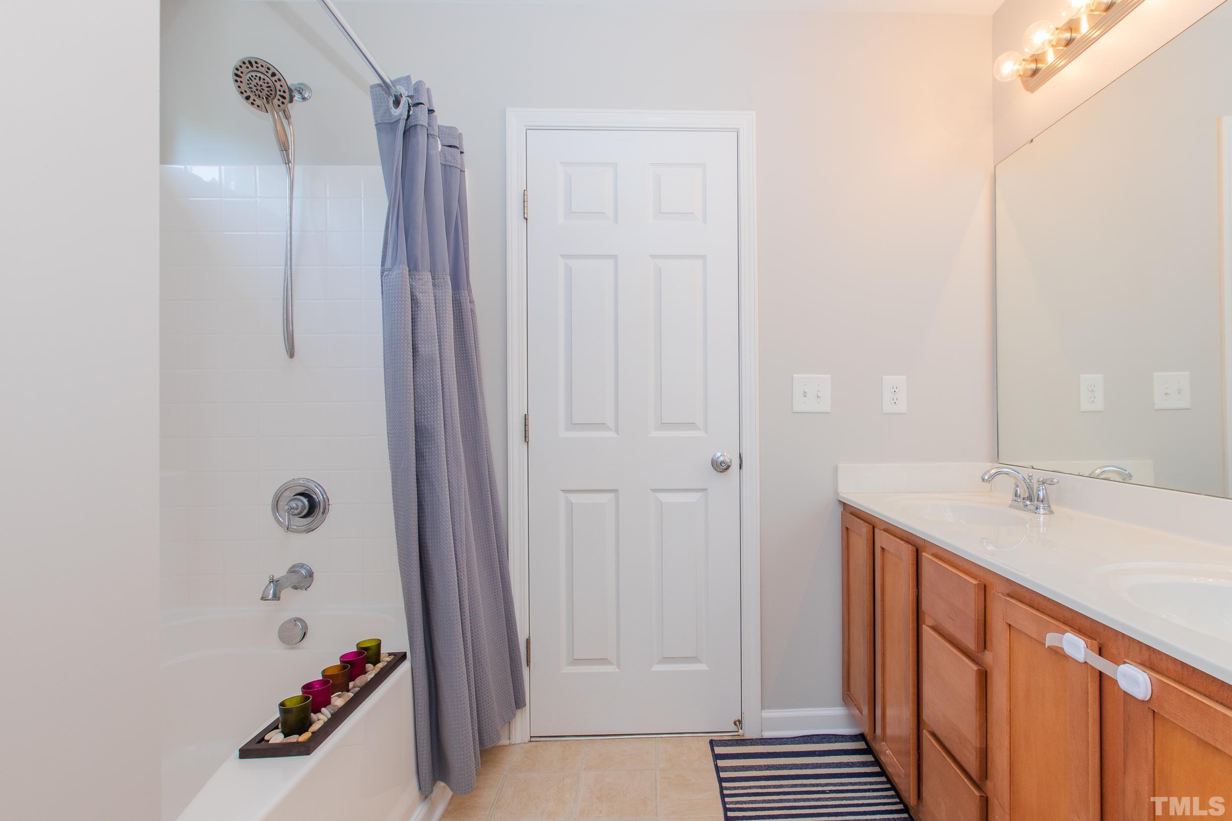 4228 Amber Stone Way Durham, NC 27704 - Photo 30 of 34 a bathroom with a double vanity sink a mirror and shower