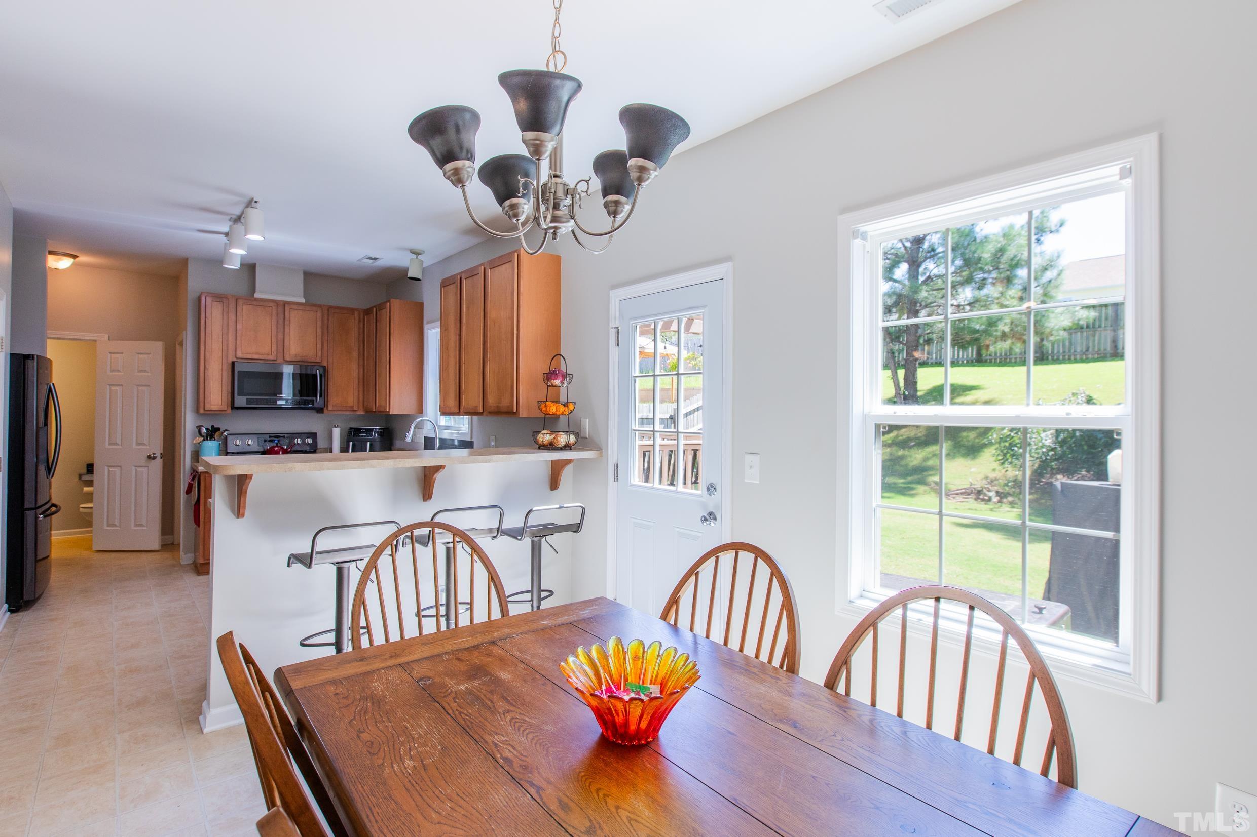 4228 Amber Stone Way Durham, NC 27704 - Photo 10 of 34 a view of a dining room with furniture a chandelier and a window