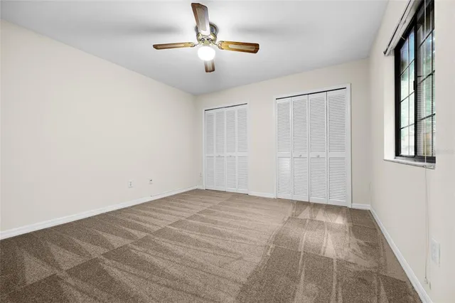 a view of an empty room with a chandelier fan