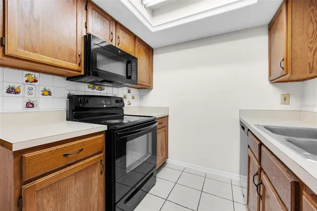 a kitchen with stainless steel appliances a stove a microwave a sink and cabinets