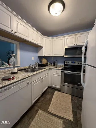 a kitchen with granite countertop a sink and stainless steel appliances