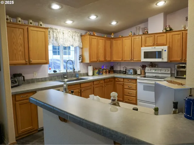 a kitchen with a sink a counter top space cabinets and stainless steel appliances