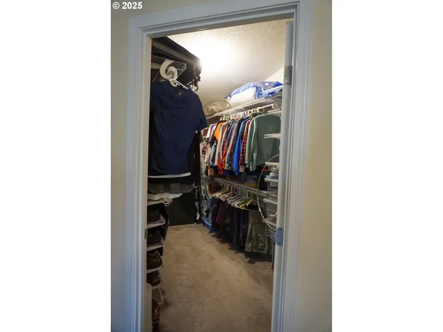 a view of walk in closet with clothes and shoes