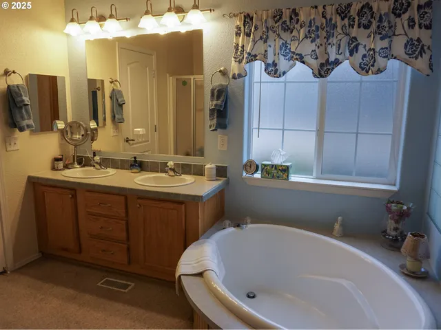 a bathroom with a tub sink and mirror