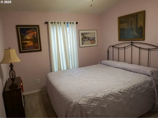 a large bed sitting in a bedroom next to a lamp