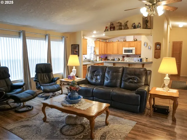 a living room with furniture a large window and a chandelier