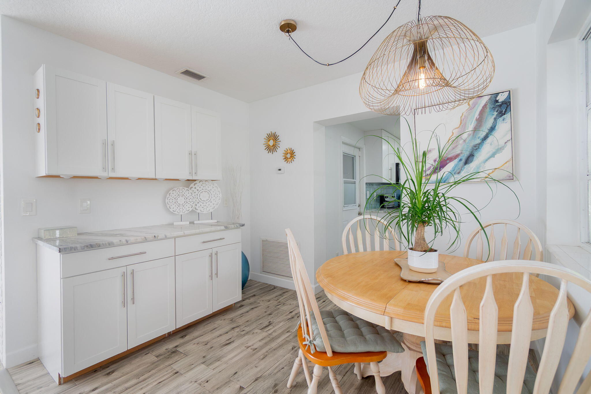 651 Ocean Inlet Drive Boynton Beach, FL 33435 - Photo 11 of 44 a kitchen with stainless steel appliances granite countertop a white cabinets a sink a dining table and chairs