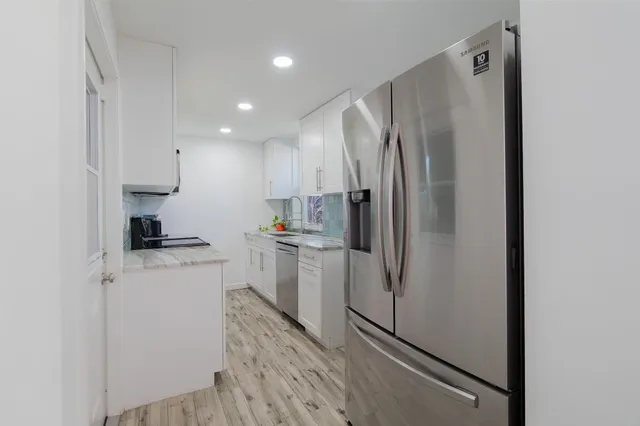 a kitchen with a refrigerator sink and cabinets