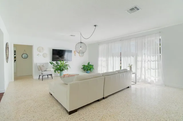 a living room with furniture and potted plants