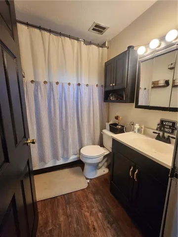 a bathroom with a granite countertop sink toilet and a mirror