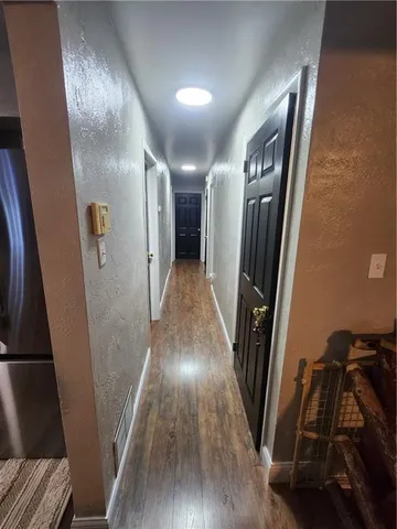 a view of a hallway with wooden floor and stairs