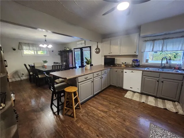 a kitchen with lots of wooden furniture appliances and dining table