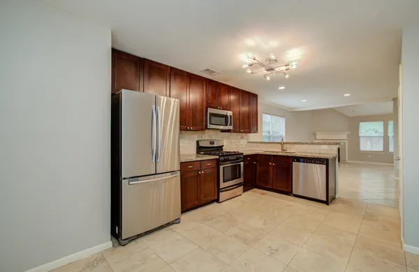 a kitchen with a refrigerator sink and wooden cabinets