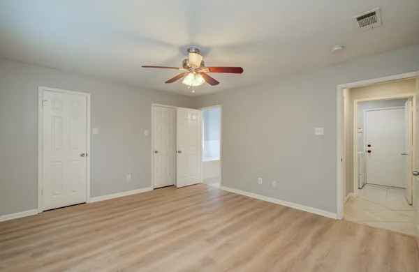 a view of an empty room with window and wooden floor