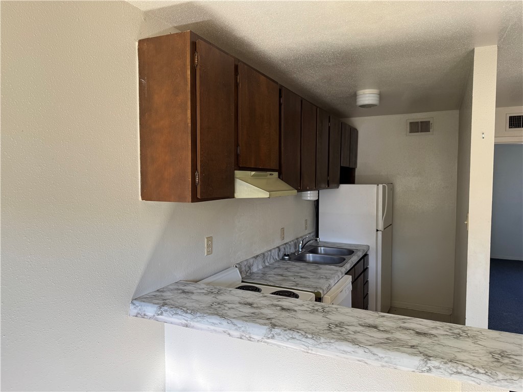 1555 Stacey Street, Unit 6 Navasota, TX 77868 - Photo 6 of 10 a kitchen with stainless steel appliances granite countertop a refrigerator and a stove top oven