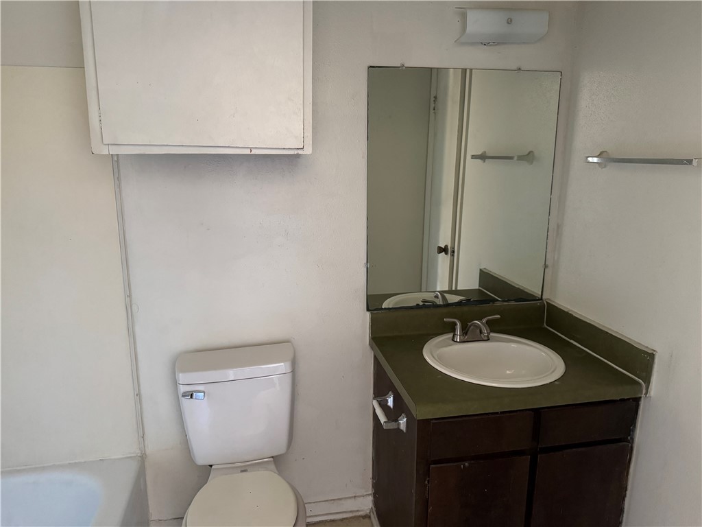 1555 Stacey Street, Unit 6 Navasota, TX 77868 - Photo 8 of 10 a bathroom with a toilet sink and mirror