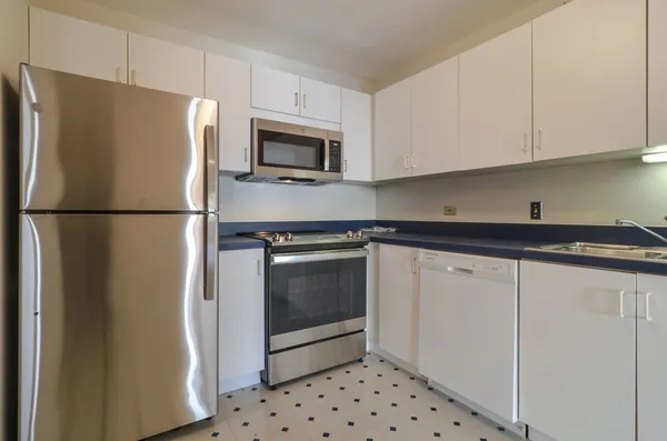 a white refrigerator freezer and a stove sitting inside of a kitchen