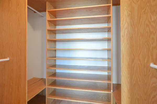 a view of walk in closet with empty racks