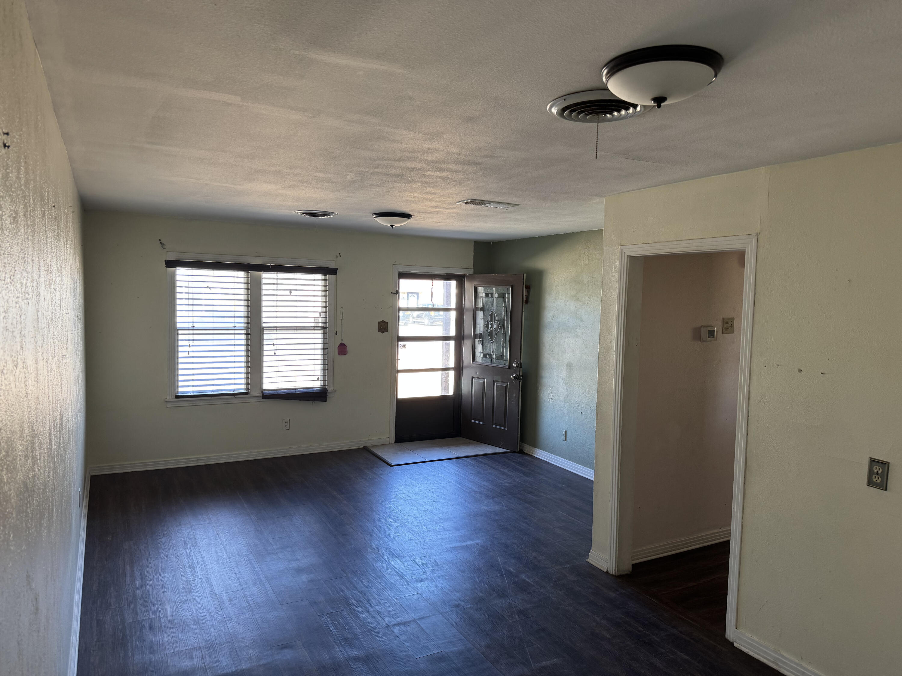 3103 Harvard Street Lubbock, TX 79415 - Photo 2 of 16 an empty room with wooden floor and windows