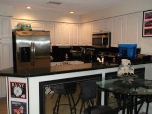 2252 Northwest 53rd Street Boca Raton, FL 33496 - Photo 7 of 7 a kitchen with stainless steel appliances granite countertop a refrigerator a stove a microwave oven a sink with island and chairs