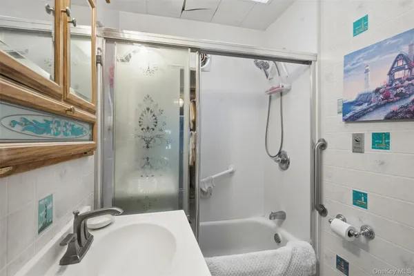 a bathroom with a bathtub shower and a sink