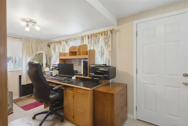 a view of a workspace with furniture and a window