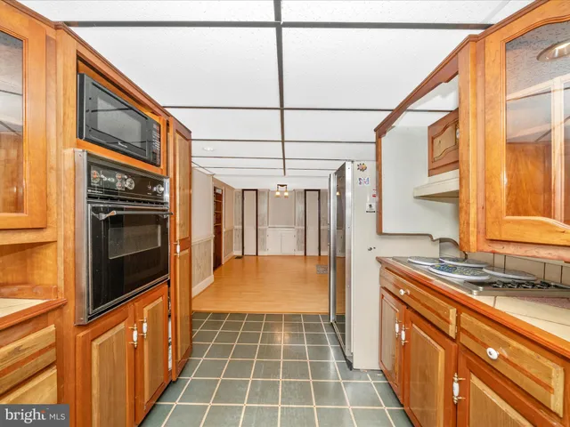 a hallway with a sink a stove and a oven with granite countertops