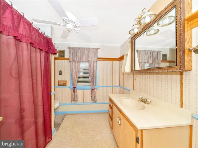 a spacious bathroom with a tub sink and mirror