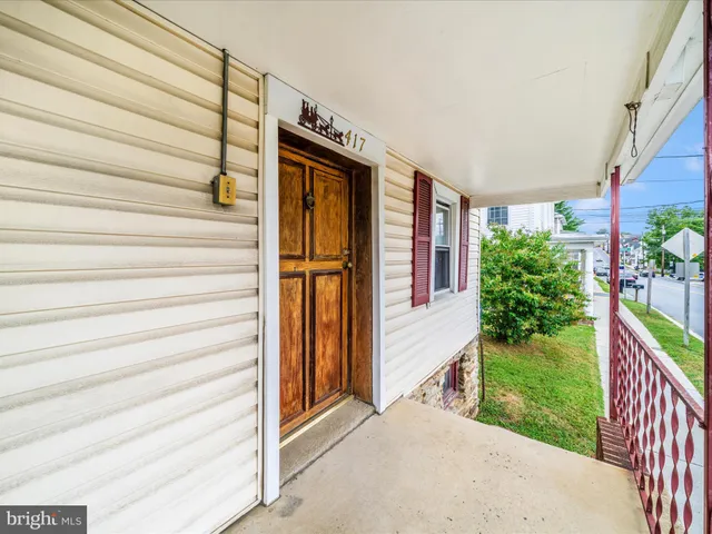 a view of a house with a yard and potted plants