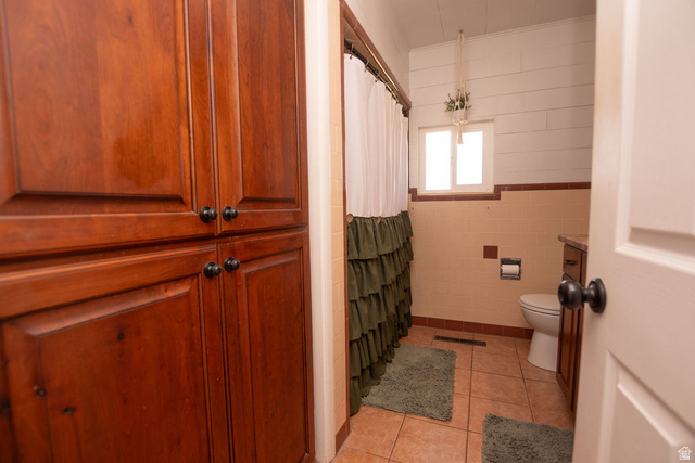 340 West 100 N Street Beaver, UT 84713 - Photo 21 of 37 Bathroom featuring a shower with shower curtain, tile walls, light tile patterned flooring, and vanity