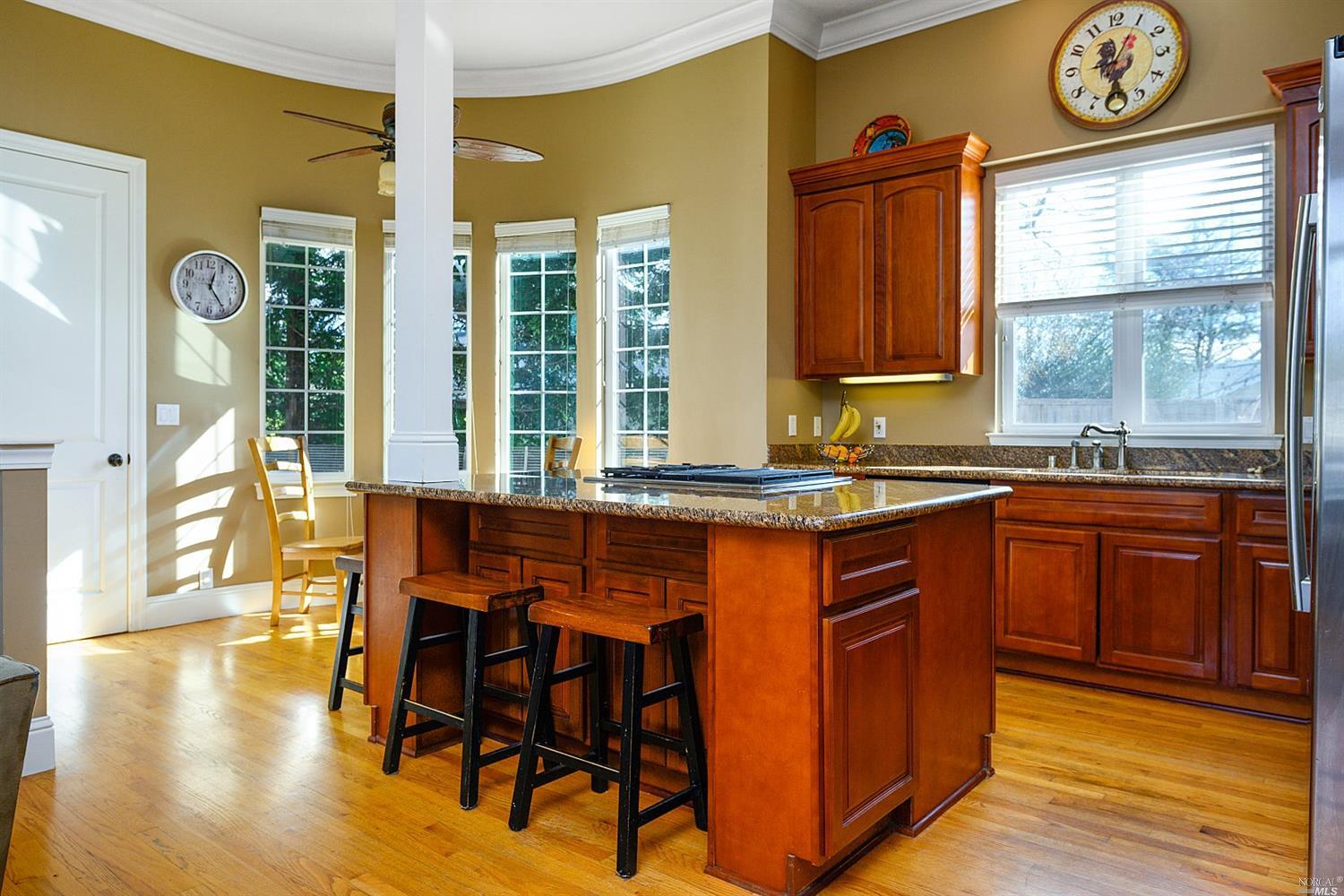 1714 Emerald Drive Calistoga, CA 94515 - Photo 1 of 1 a kitchen with stainless steel appliances granite countertop wooden floor a dining table and chairs