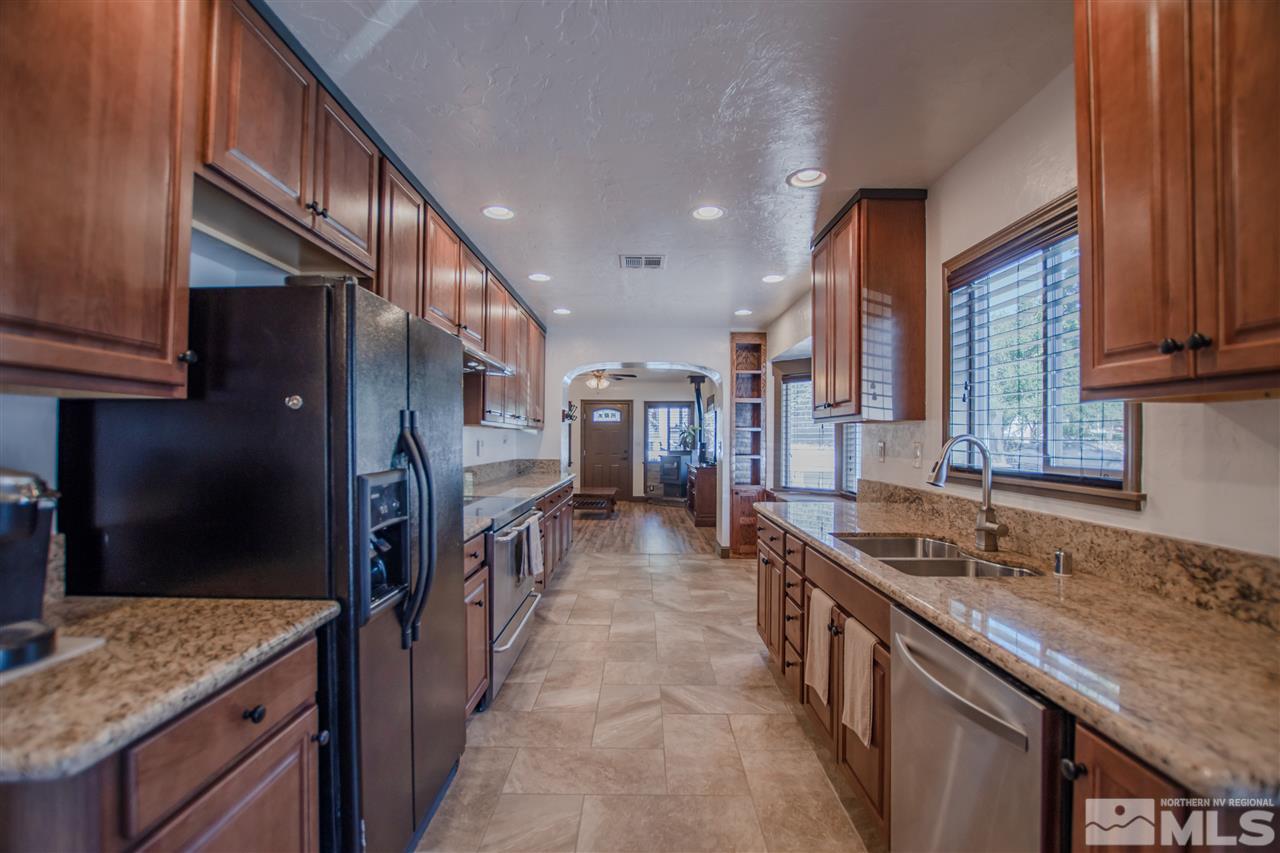 1611 Plumas Street Reno, NV 89509 - Photo 7 of 25 a kitchen with stainless steel appliances granite countertop a sink and a refrigerator