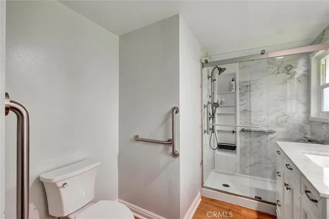 a bathroom with a granite countertop shower a toilet and a sink