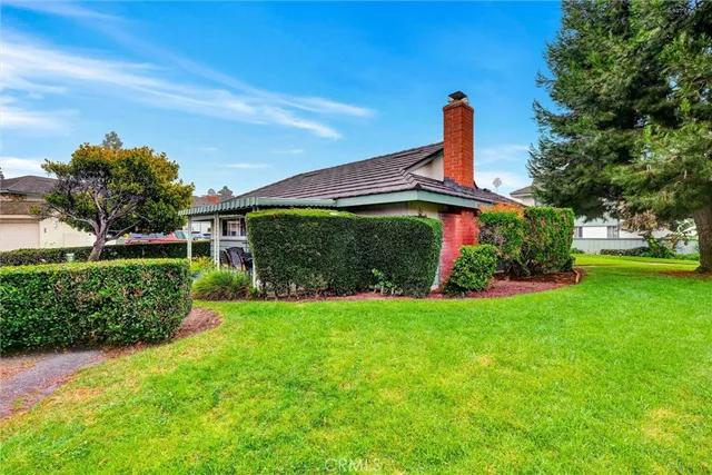 a front view of a house with a yard and potted plants