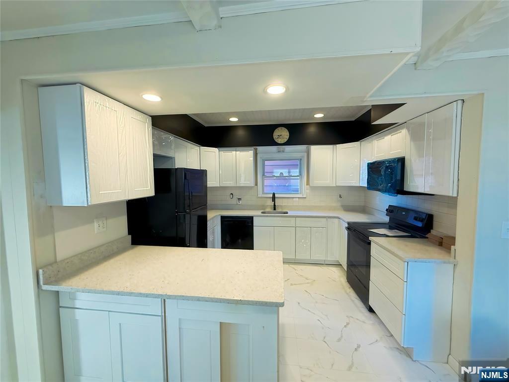 16 Corabelle Avenue Lodi, NJ 07644 - Photo 5 of 20 a kitchen with a sink a counter top space stainless steel appliances and cabinets