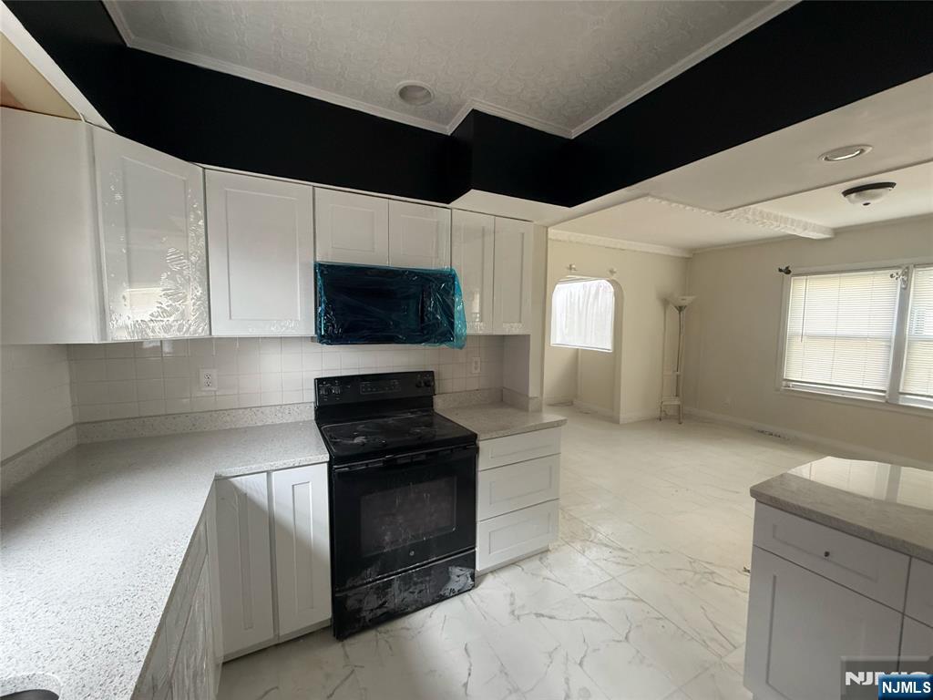 16 Corabelle Avenue Lodi, NJ 07644 - Photo 10 of 20 a kitchen with stainless steel appliances kitchen island granite countertop a stove a sink and a microwave