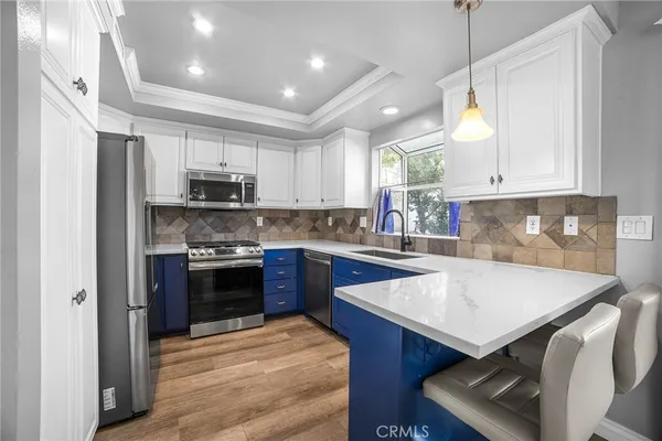 a kitchen with stainless steel appliances a stove a sink a microwave a refrigerator and cabinets