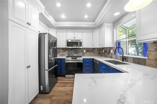 a kitchen with stainless steel appliances granite countertop a refrigerator stove and sink