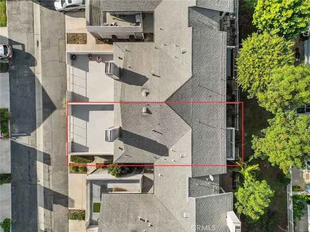 an aerial view of residential houses with outdoor space and trees