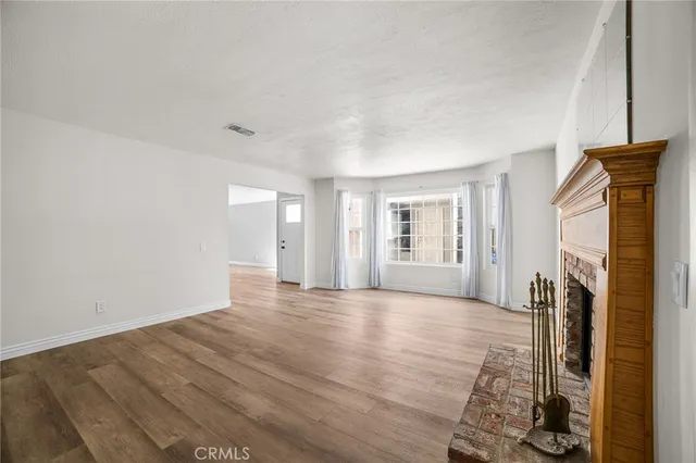 an empty room with wooden floor and window