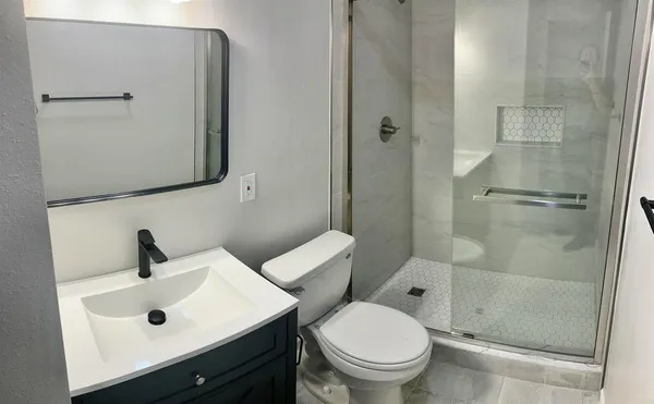 a bathroom with a shower a toilet and a sink