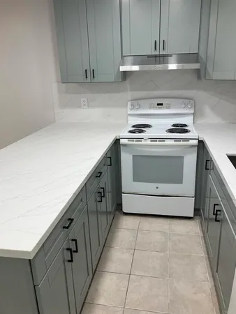 a kitchen with granite countertop white cabinets and white appliances