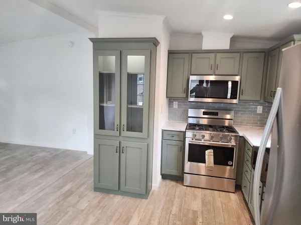a kitchen with granite countertop a stove and stainless steel appliances