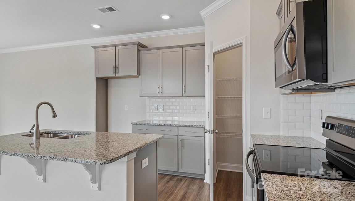 343 Lagoon Road Fletcher, NC 28732 - Photo 8 of 32 a kitchen with a sink and a stove top oven with wooden floor