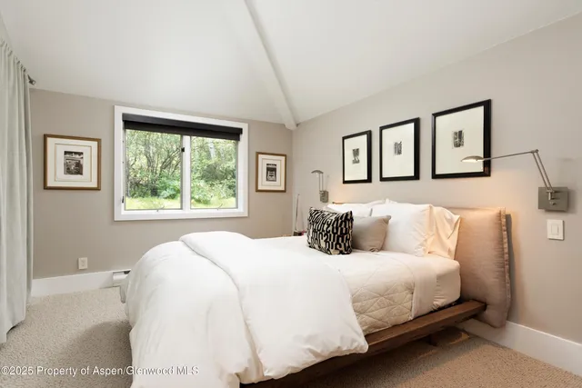 a bedroom with a large bed and a window