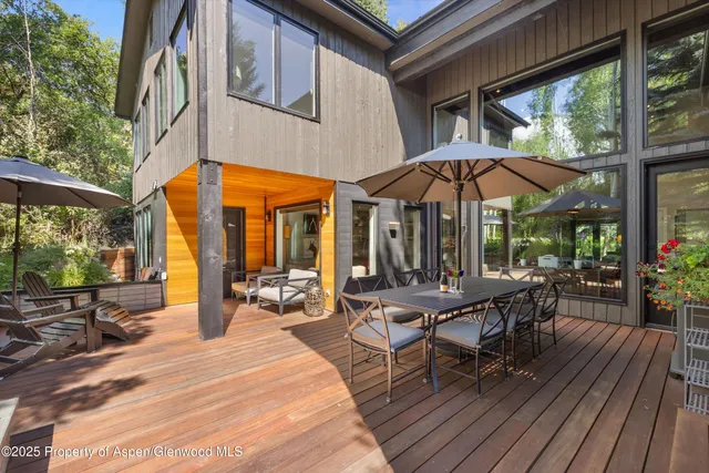 a view of a dinning tables and chairs in the patio in front of a house