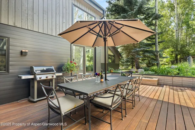 a view of a roof deck with table and chairs under an umbrella
