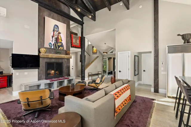a living room with furniture a flat screen tv and a fireplace