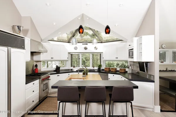 a kitchen with stainless steel appliances lots of counter space dining table and chairs