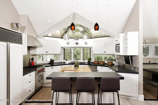 a kitchen with stainless steel appliances lots of counter space dining table and chairs